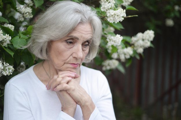 Portrait of senior sad woman in park