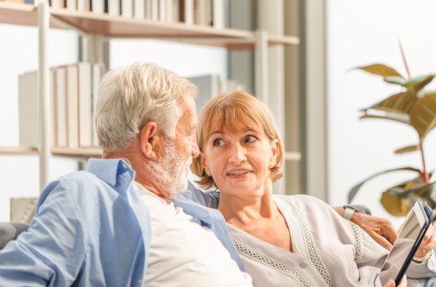 Senior couple in living room, Elderly man and a woman using tabl