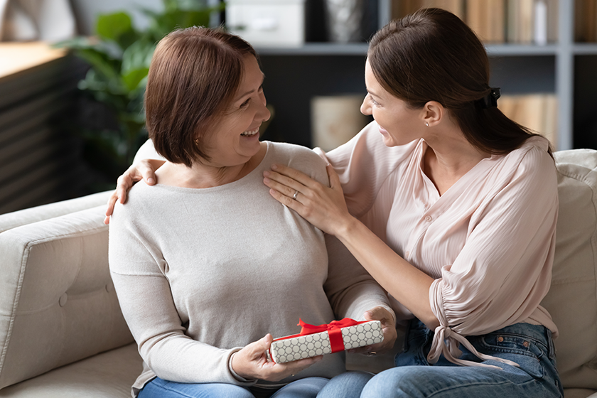 adult daughter congratulating smiling older mother adult daughter congratulating smiling older mother