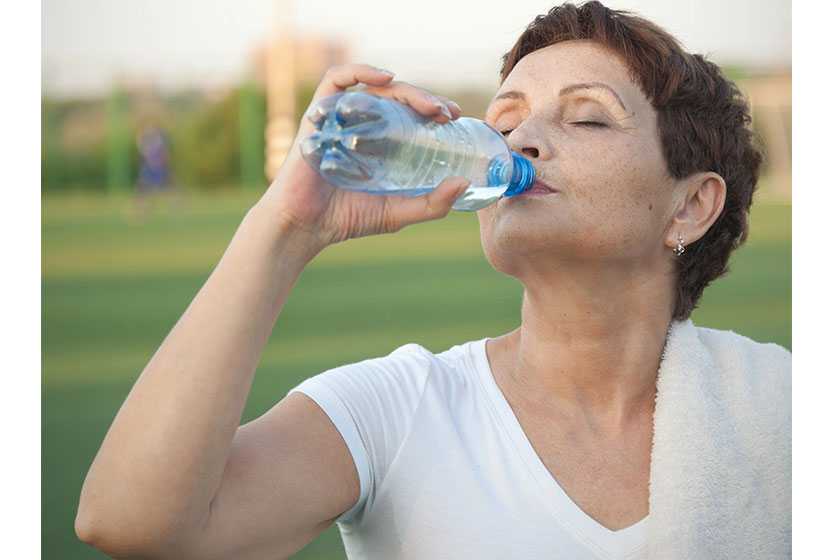 Attractive woman 50 years old drinking water after fitness Attractive woman 50 years old drinking water after fitness