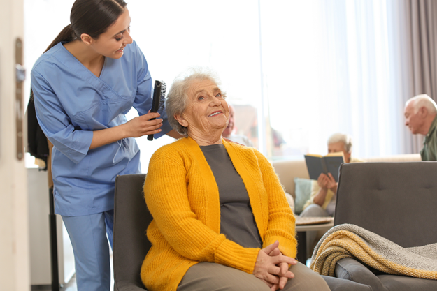 care worker brushing elderly woman care worker brushing elderly woman