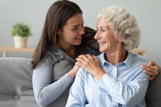Caring young granddaughter embrace happy old grandma at home Caring young granddaughter embrace happy old grandma at home