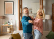 Cheerful mature spouses dancing enjoying senior life having fun modern