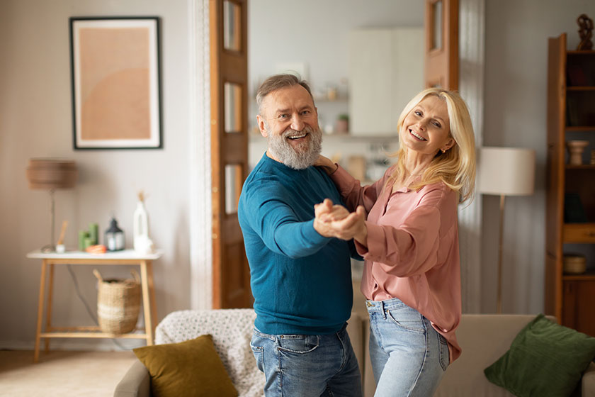 Cheerful mature spouses dancing enjoying senior life having fun modern