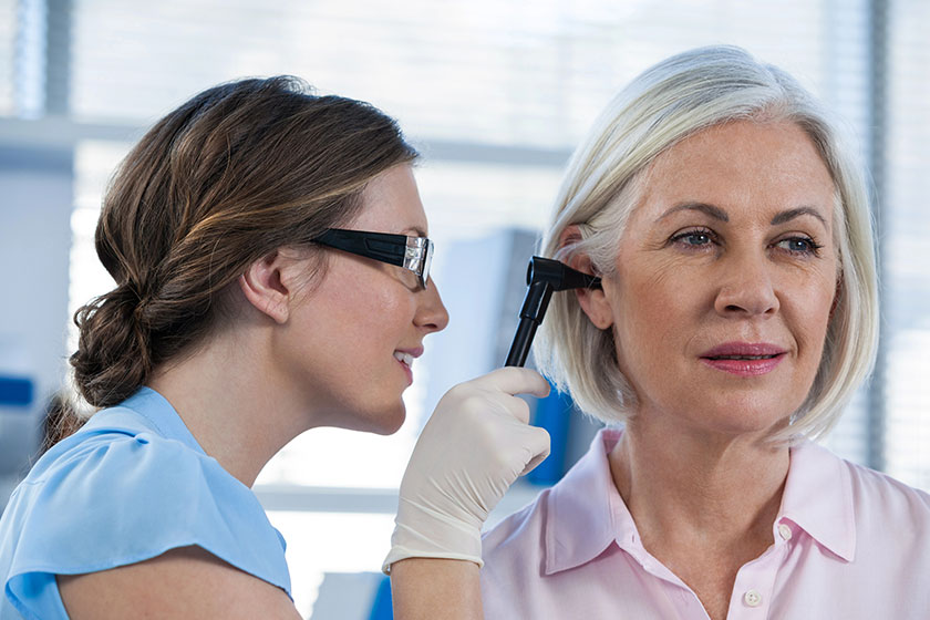 Doctor examining patients ear with otoscope Doctor examining patients ear with otoscope