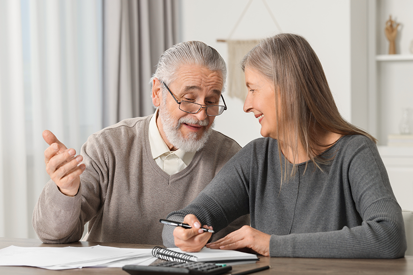 elderly couple papers discussing pension plan