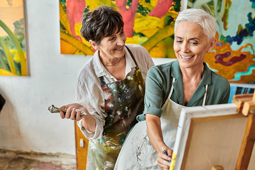 Happy middle aged woman painting easel skillful female artist master Happy middle aged woman painting easel skillful female artist master