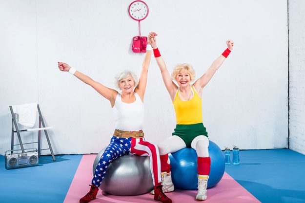 Happy senior sportswomen sitting fitness balls smiling camera Happy senior sportswomen sitting fitness balls smiling camera