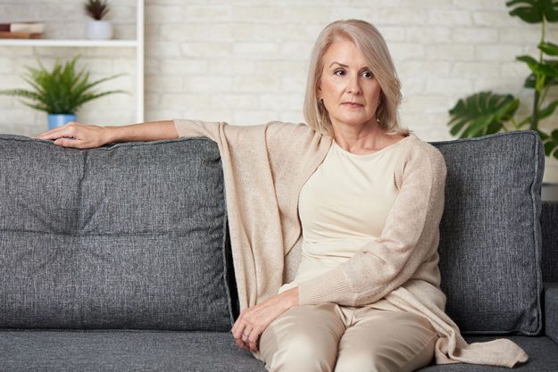portrait sad older woman sitting sofa home portrait sad older woman sitting sofa home