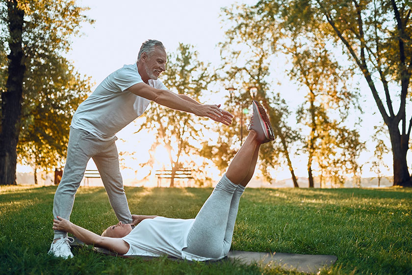 Senior couple doing sport outdoors stretching park sunrise doing yoga Senior couple doing sport outdoors stretching park sunrise doing yoga