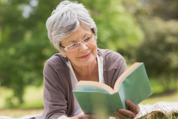 senior woman reading a book at park