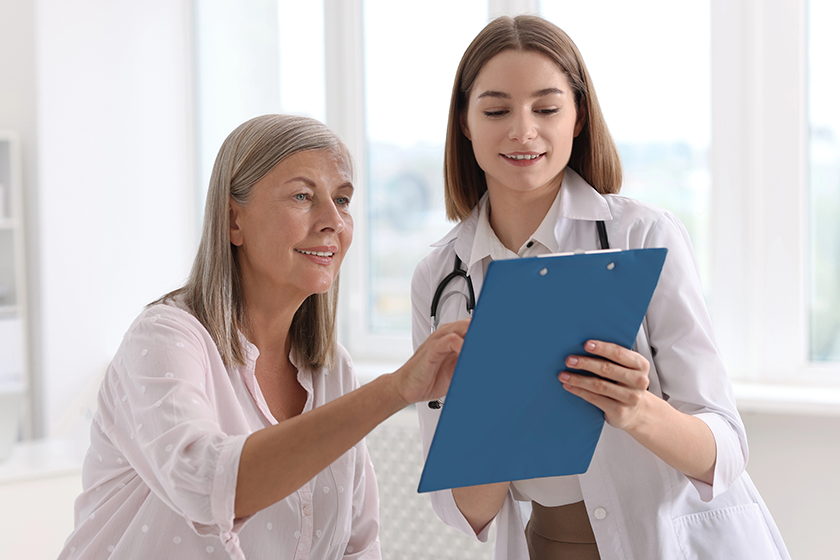 smiling healthcare worker clipboard consulting senior patient