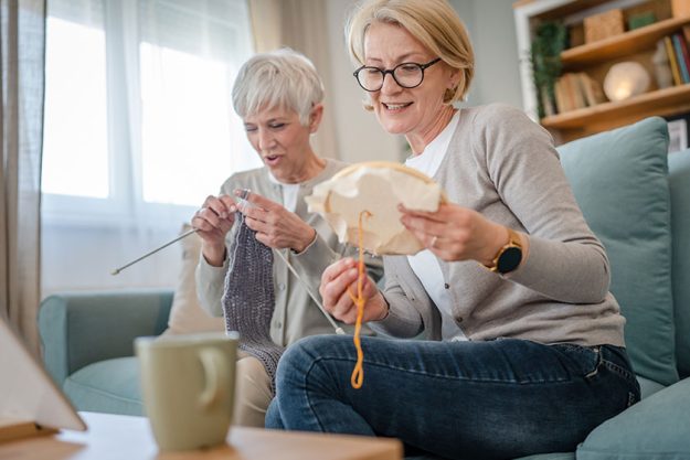 Two women senior mature caucasian friends mother daughter sisters knitting Two women senior mature caucasian friends mother daughter sisters knitting