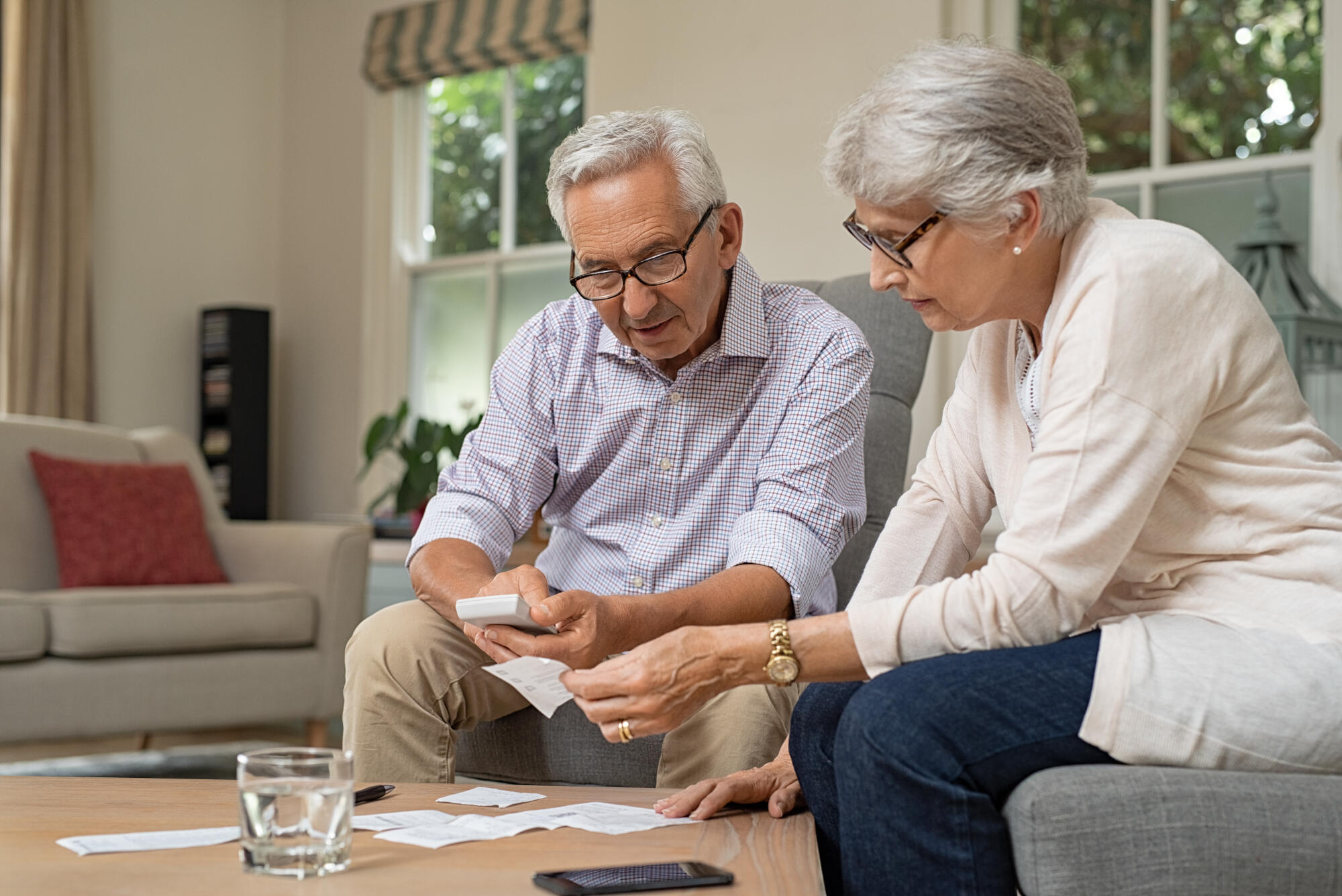 Smiling,Senior,Couple,With,Papers,,Calculators,And,Bills,At,Home. Smiling,Senior,Couple,With,Papers,,Calculators,And,Bills,At,Home.
