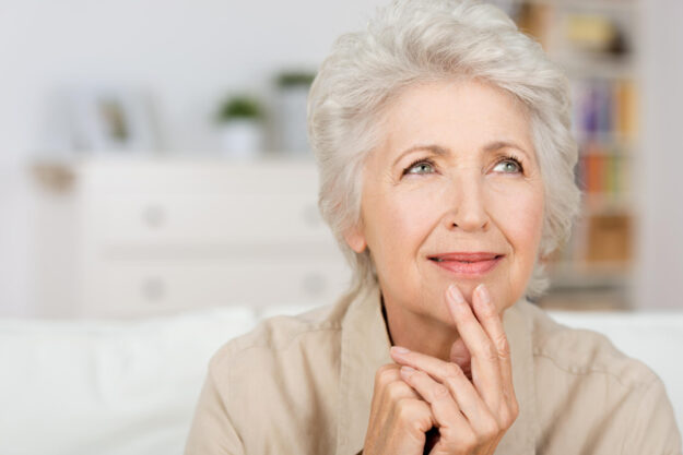 Thoughtful,Senior,Lady,Sitting,At,Home,With,Her,Fingers,To