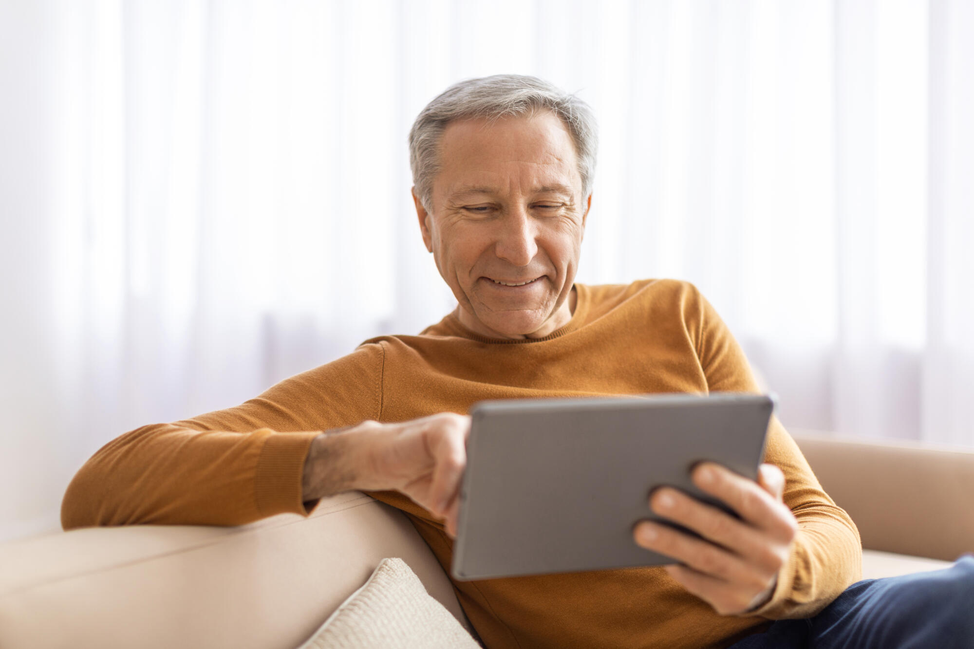 Relaxed senior man using digital tablet at home Relaxed senior man using digital tablet at home