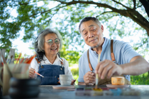 In the pottery workshop, an Asian retired couple is engaged in p