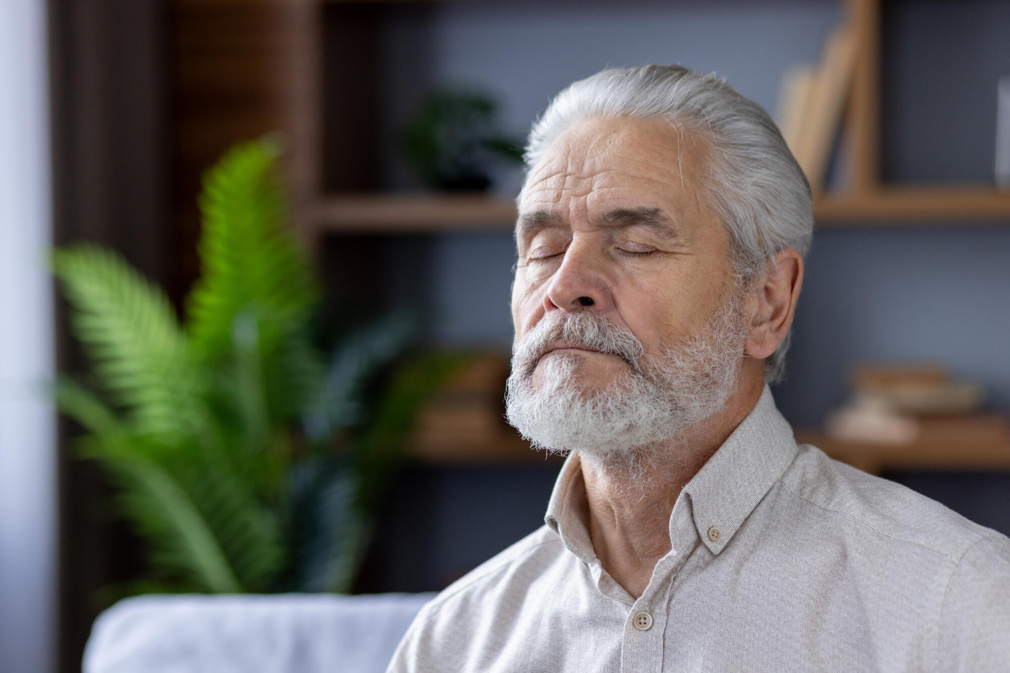 Senior man meditating peacefully in a modern home Senior man meditating peacefully in a modern home