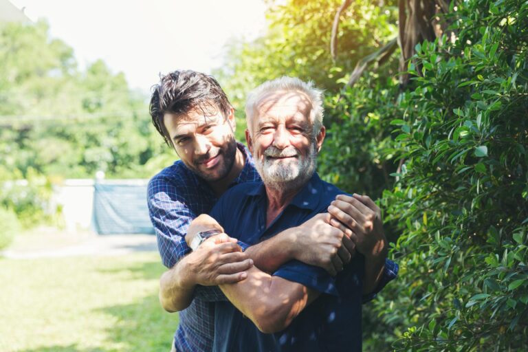 Senior,Father,And,Adult,Son,Hugging,Together,In,The,Garden Senior,Father,And,Adult,Son,Hugging,Together,In,The,Garden