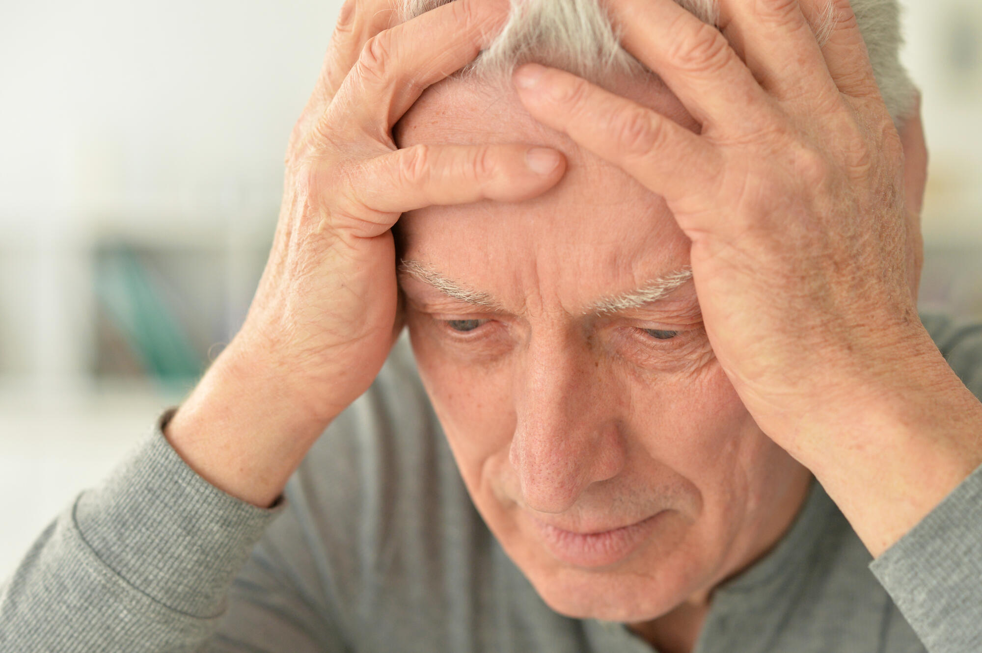 Elderly man suffering from a headache at home