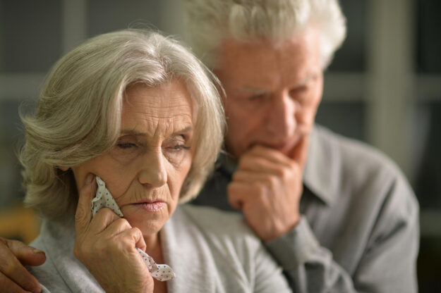 Portrait of sick elderly couple at home