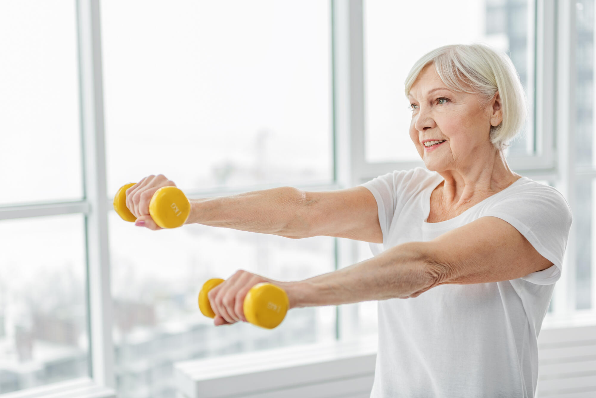Cheerful,Senior,Lady,Exercising,With,Weights