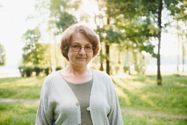 Senior woman walking in the park in summer.