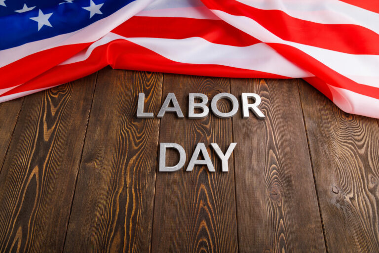 words labor day laid with silver metal letters on wooden surface with crumpled USA flag on left side words labor day laid with silver metal letters on wooden surface with crumpled USA flag on left side