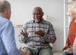 Cheerful african american elderly man having conversation with coach