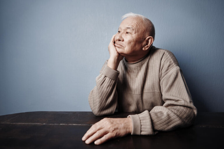 Pensive and thoughtful senior man sitting at the table Pensive and thoughtful senior man sitting at the table