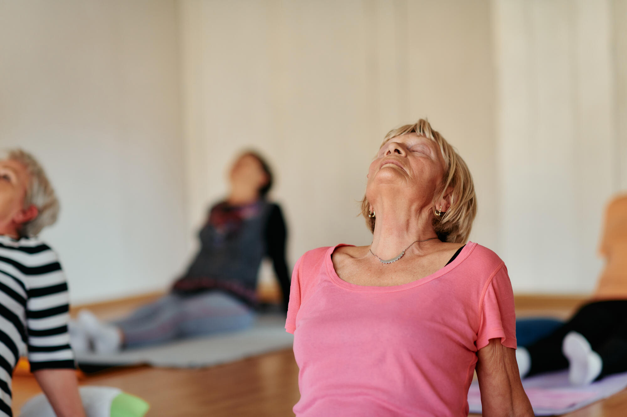 Senior Women Embrace Wellness: Yoga and Stretching in a Sunlit Space
