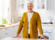 Happy senior lady posing in kitchen at home