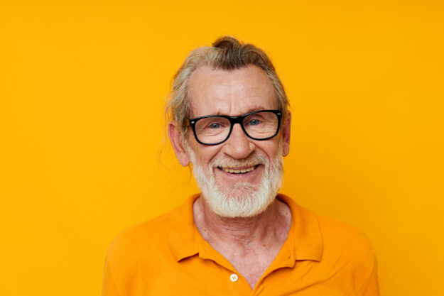 an elderly man with glasses in a yellow t shirt with glasses close up an elderly man with glasses in a yellow t shirt with glasses close up