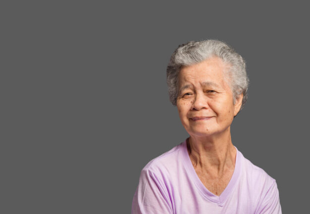 An elderly Asian woman looking at the camera with a smile while An elderly Asian woman looking at the camera with a smile while