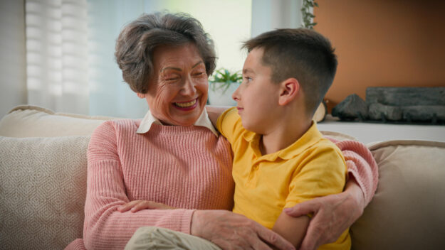 Caucasian happy family two generations elderly retired woman grandmother talking hugging boy child grandson speaking enjoying communication at home on couch grandma talk hug embrace cuddle grandchild Caucasian happy family two generations elderly retired woman grandmother talking hugging boy child grandson speaking enjoying communication at home on couch grandma talk hug embrace cuddle grandchild