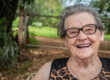 Senior happy old farmer woman with eyeglasses smiling and looking at camera