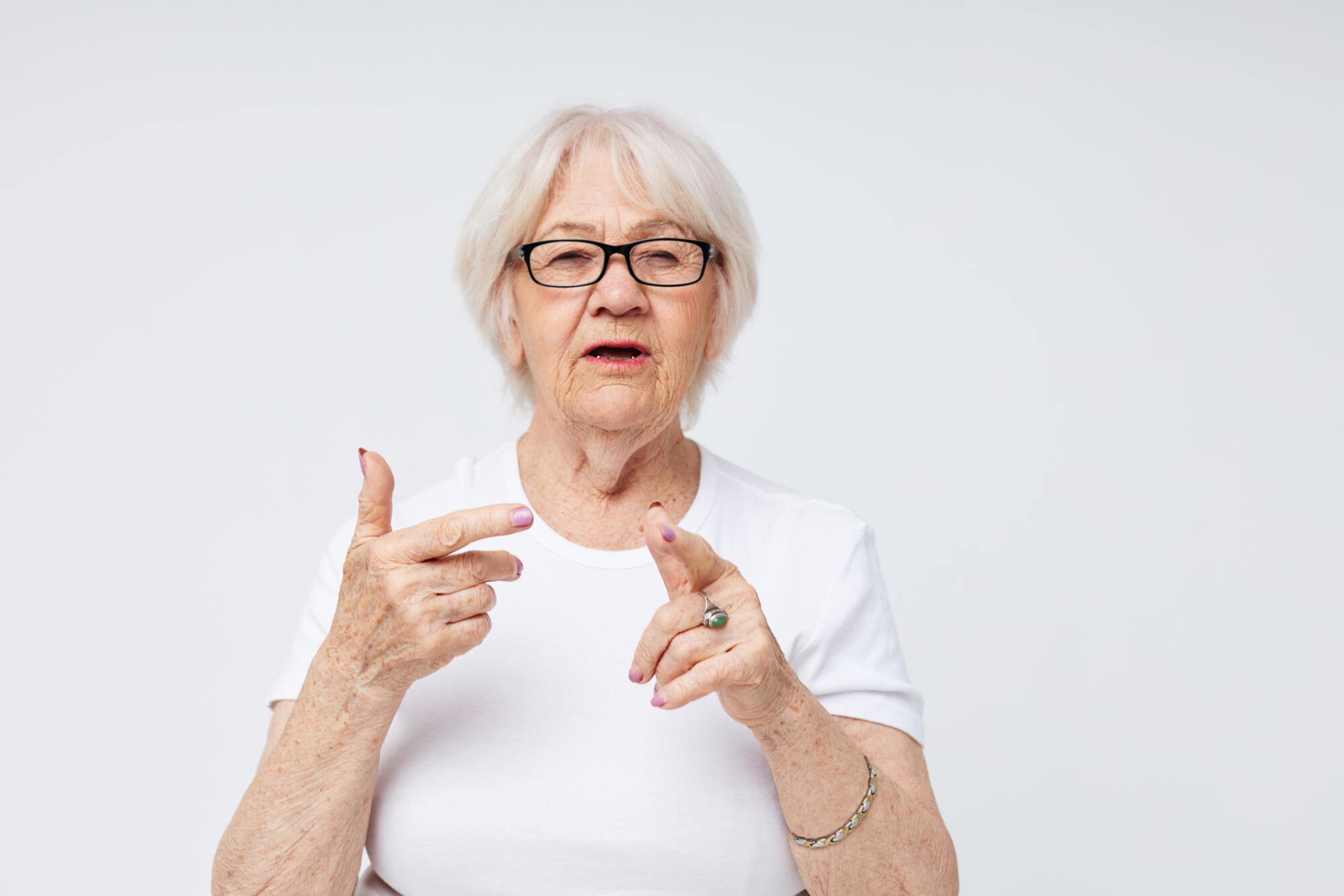 Portrait of an old friendly woman vision problems with glasses light background