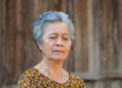 Senior woman with short gray hair, looking down and the face of