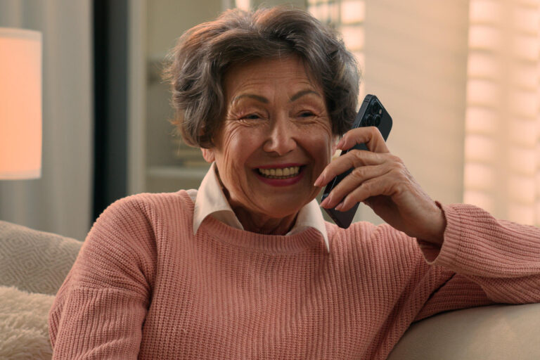 Happy laughing talking phone Caucasian old woman carefree senior lady listening funny news smile laugh retired grandma elderly female grandmother mobile conversation smartphone communication at home