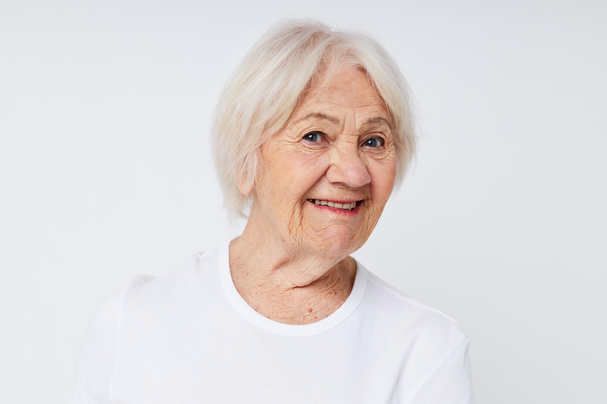 close up of a cheerful elderly woman in a white t shirt