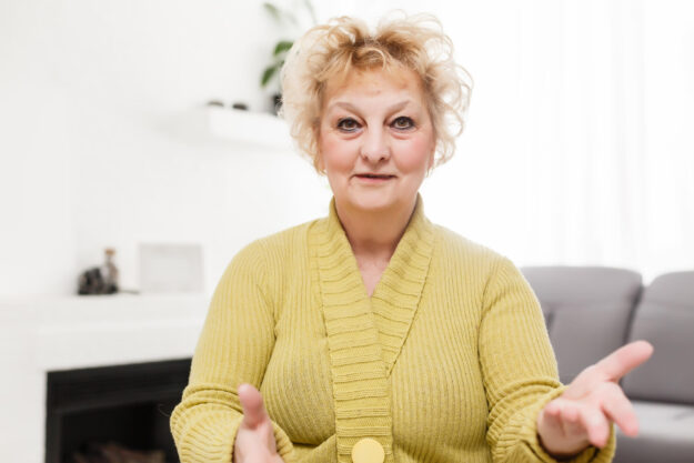 Smiling middle aged mature grey haired woman looking at camera, happy old lady posing at home indoor, positive single senior retired female sitting on sofa in living room headshot portrait Smiling middle aged mature grey haired woman looking at camera, happy old lady posing at home indoor, positive single senior retired female sitting on sofa in living room headshot portrait