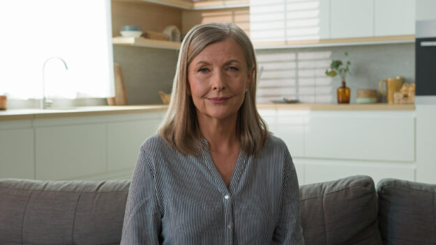 Happy smiling mature retired 70s Caucasian woman mother healthy grandmother gray haired pensioner posing looking at camera. Old elderly senior lady female mortgage couch at home rent house household Happy smiling mature retired 70s Caucasian woman mother healthy grandmother gray haired pensioner posing looking at camera. Old elderly senior lady female mortgage couch at home rent house household