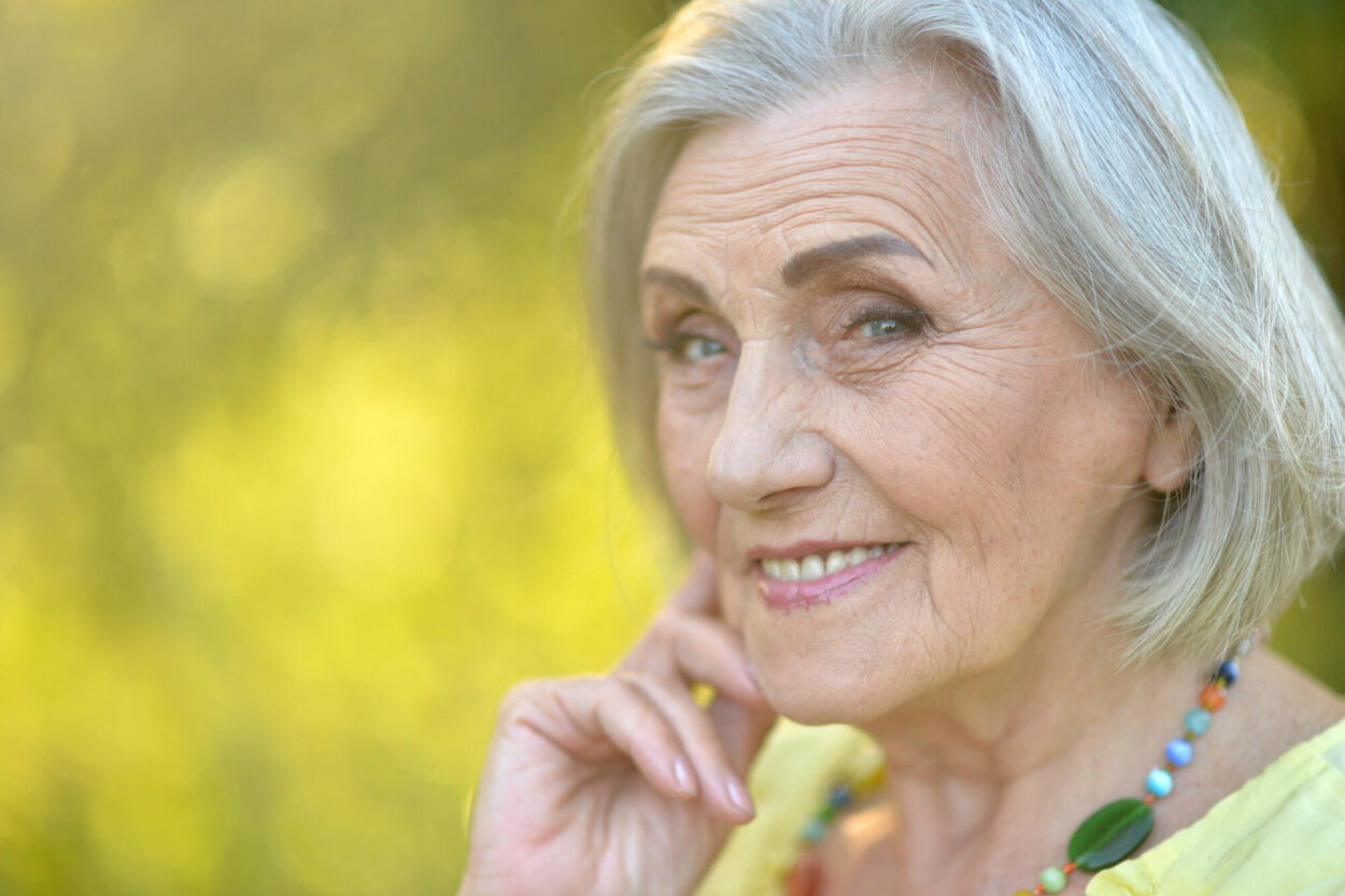 Close up portrait of happy smiling senior woman in park