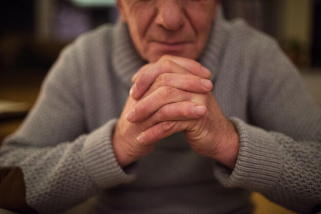 Unrecognizable,Senior,Man,At,Home,Praying,,Hands,Clasped,Togethe