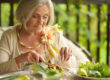 Happy elderly woman enjoying a meal outdoors
