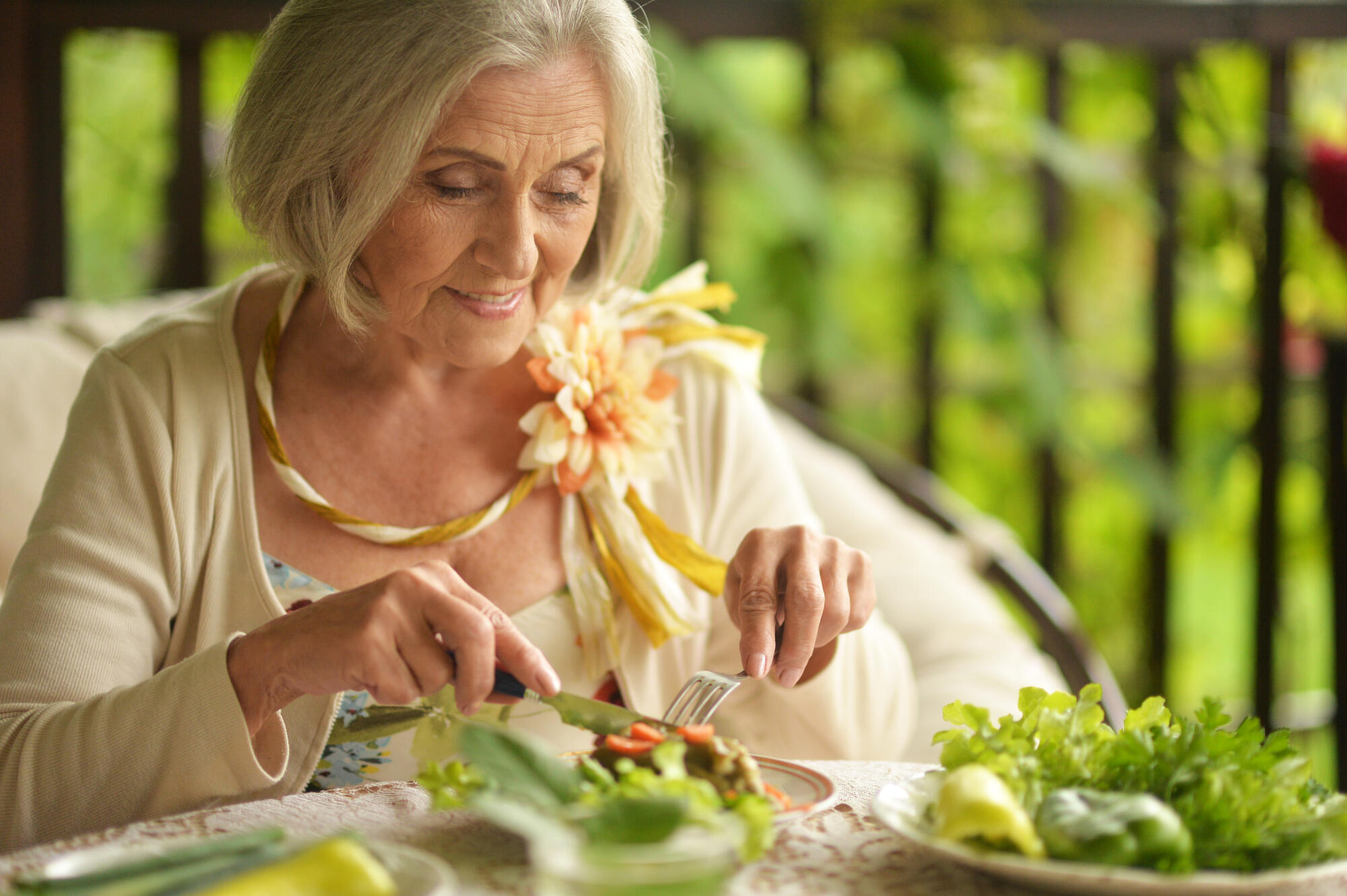 Happy elderly woman enjoying a meal outdoors Happy elderly woman enjoying a meal outdoors