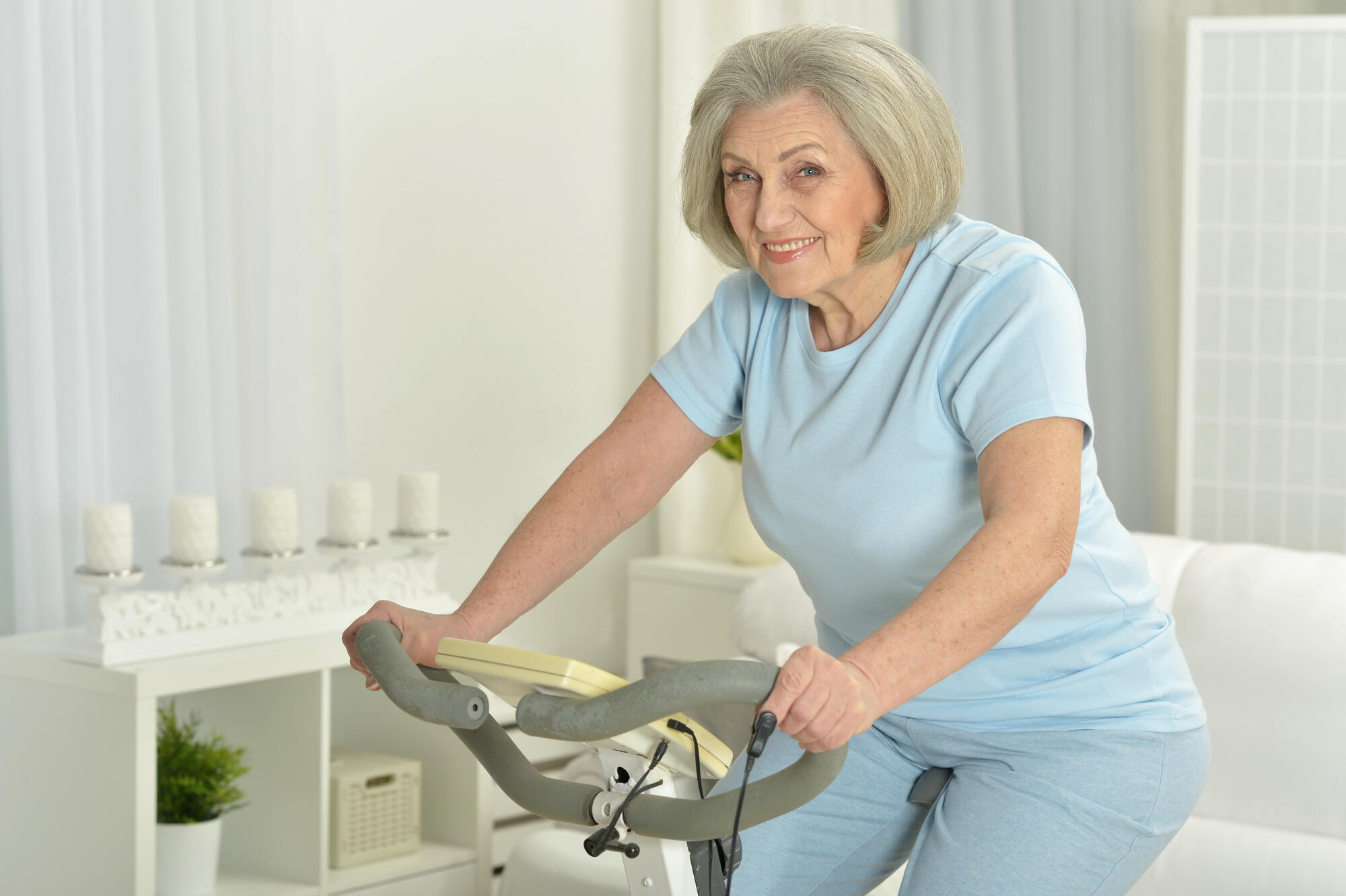 Elderly woman exercising on an exercise bike Elderly woman exercising on an exercise bike