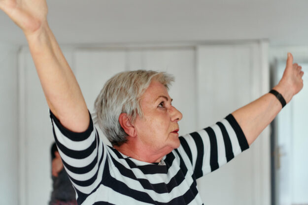 Senior Women Embrace Wellness: Yoga and Stretching in a Sunlit Space
