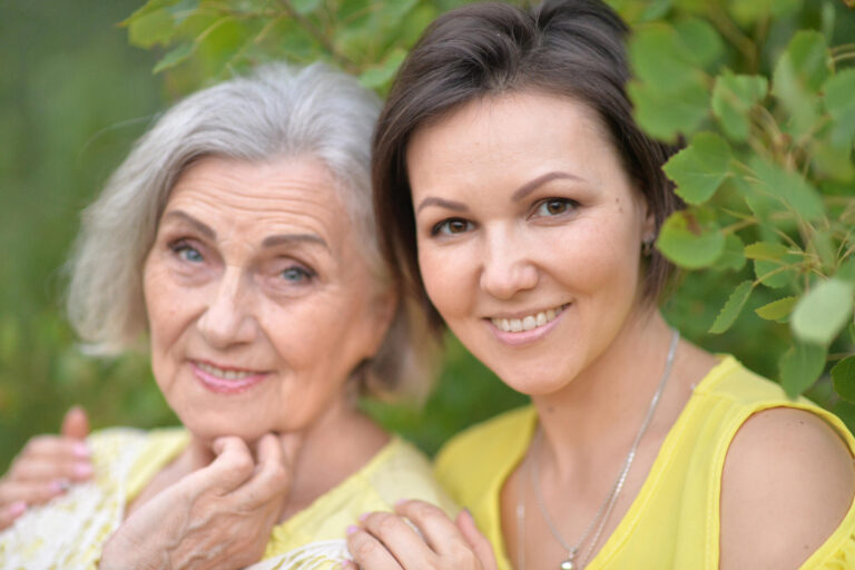 Beautiful elderly woman with her daughter walking in park