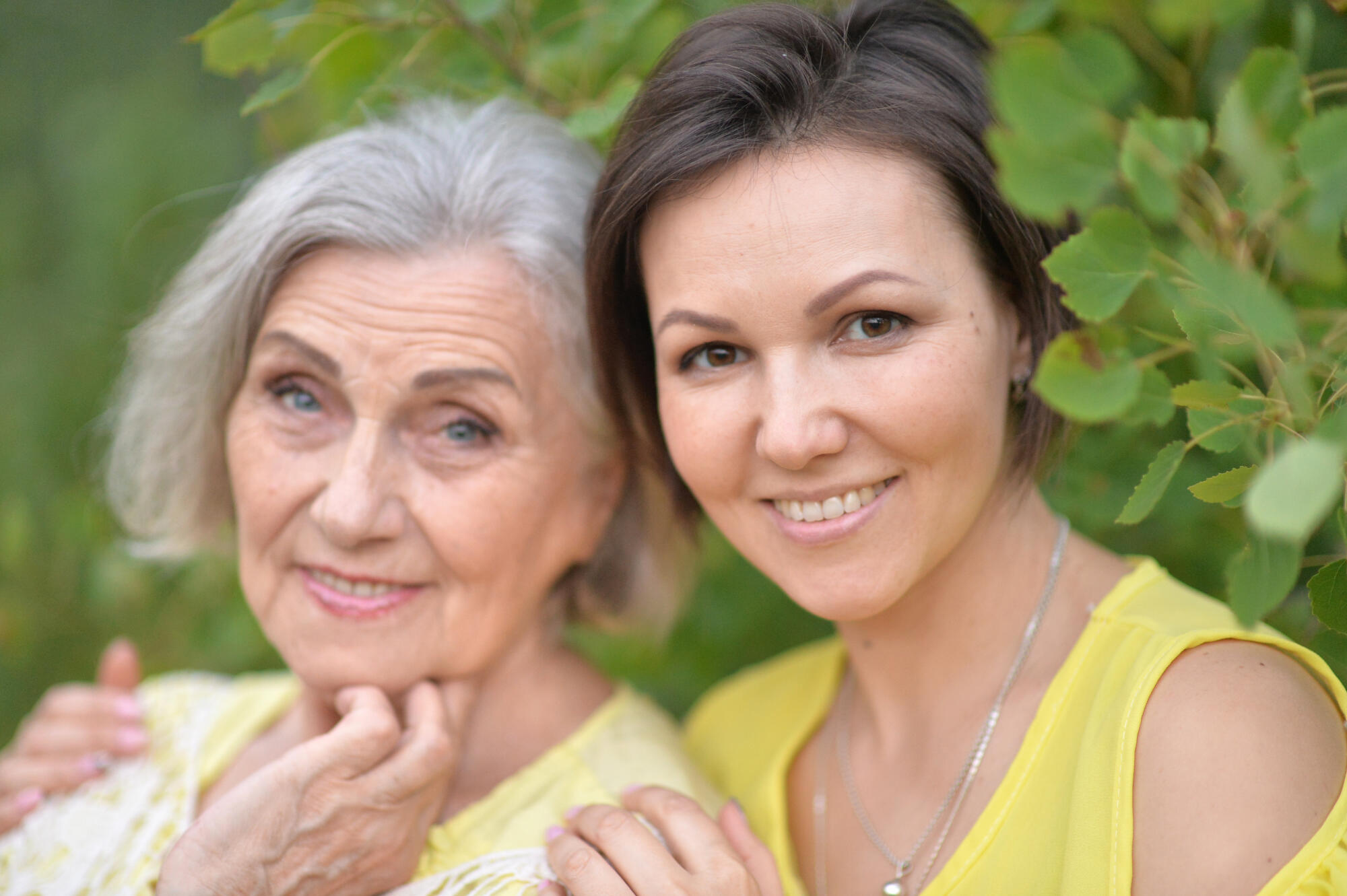 Beautiful elderly woman with her daughter walking in park